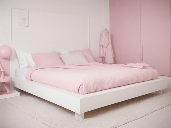 White bed pink sheets bright room