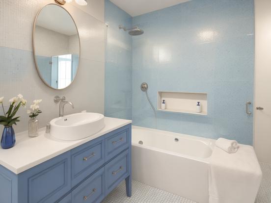 Blue vanity white tub bathroom