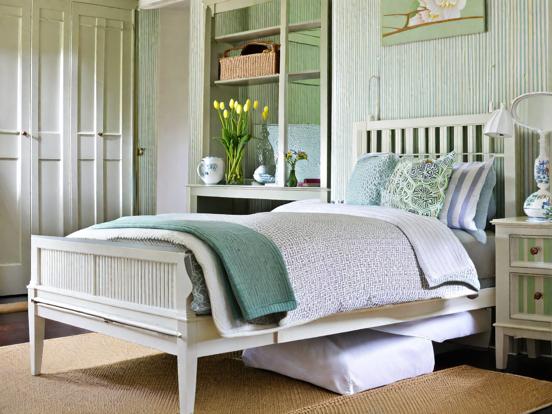 White frame bed green blanket