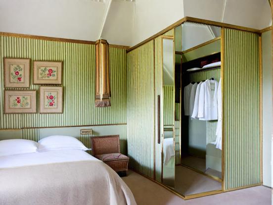 Bedroom with green walls and gold linens