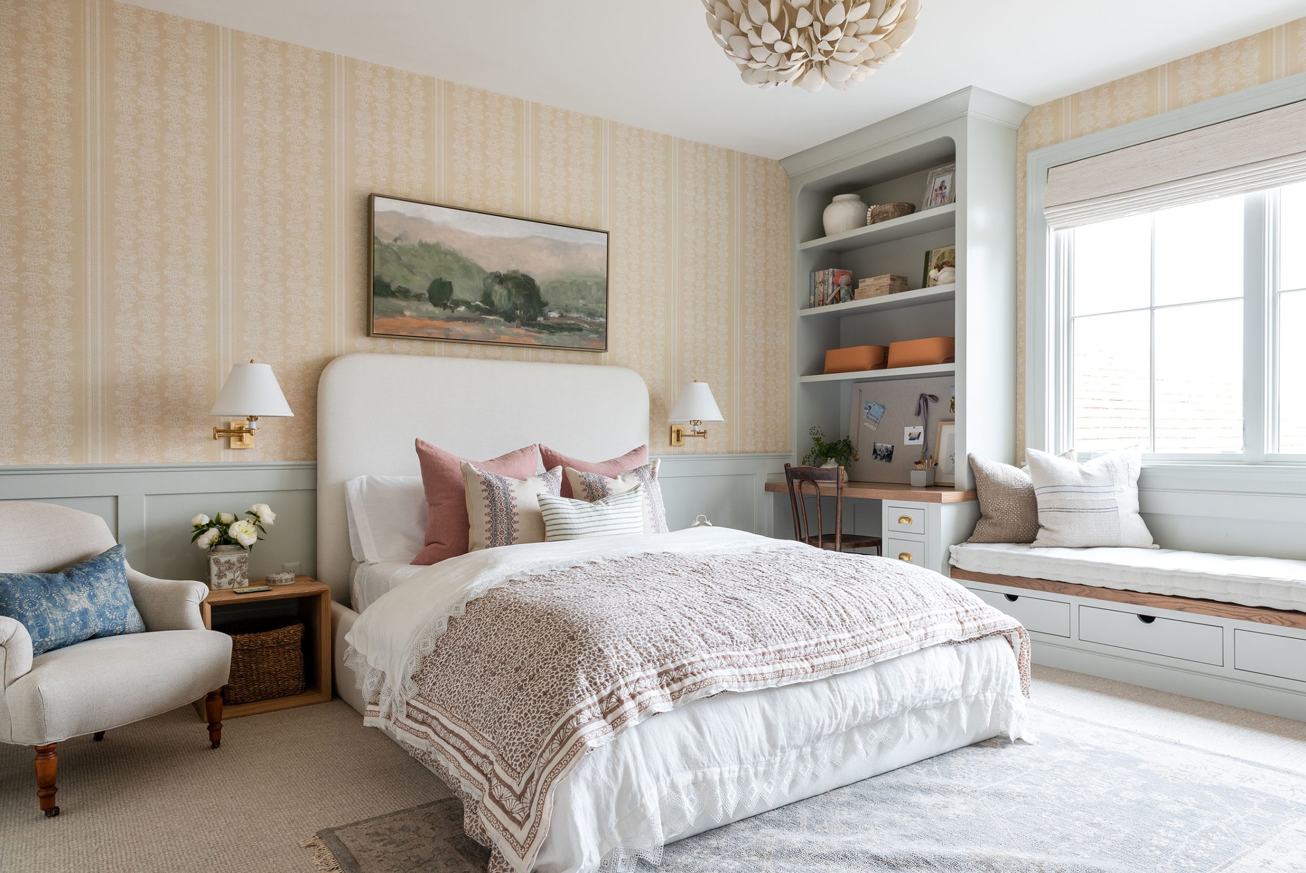 bedroom with yellow wallpaper and blue paneling with pink toned bedding